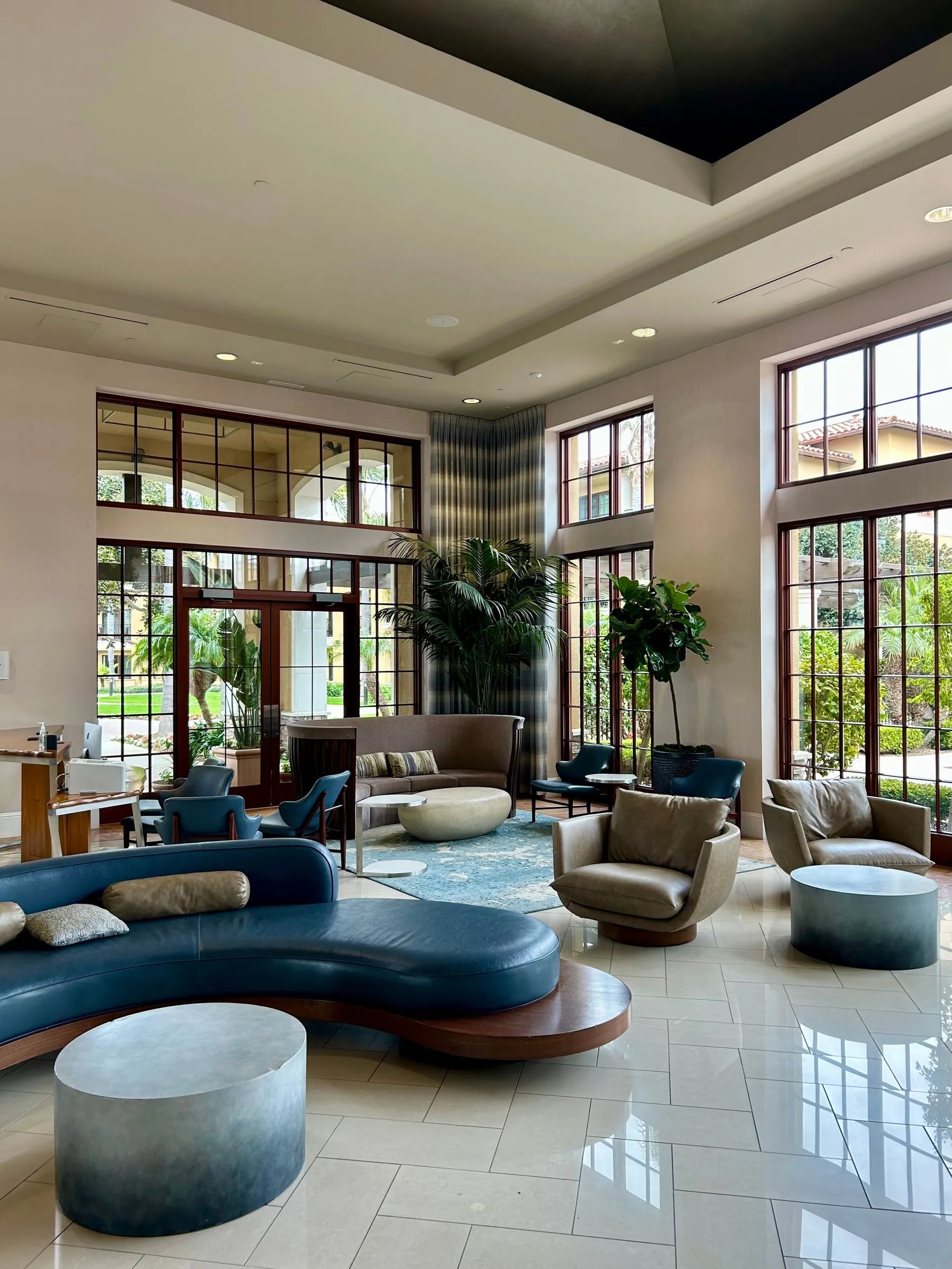A spacious modern lobby with glass walls and lounge seating