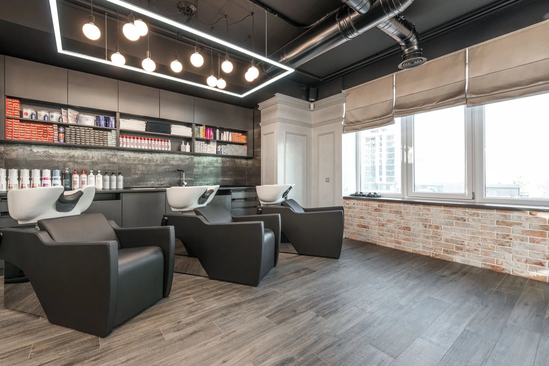 A salon with backwash chairs and large windows