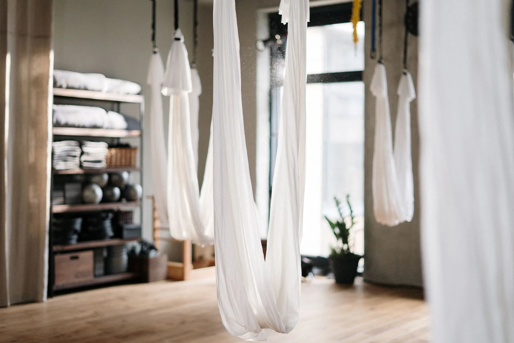 A studio with aerial hammocks and storage shelves